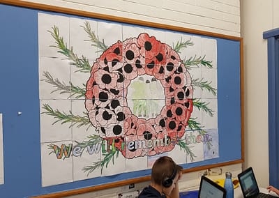 Picture of an ANZAC wreath coloured by school students displayed in a classroom
