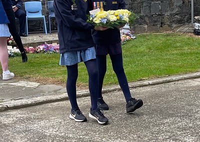 Two students in school uniform laying a wreath at the Deloraine Cenotaph